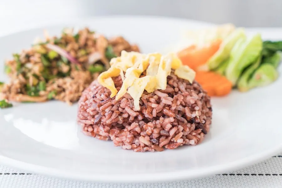 Brown Rice in a ceramic bowl showing its natural whole grain texture